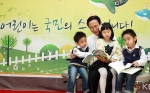 KB창작동화제 시상식에서 민병덕 은행장(사진 왼쪽 두번째)이 시상식에 참석한 어린이들에게 창작동화집<동화는내친구>를 읽어주고 있다.