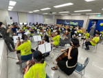 한여름, 음악캠프에 참가한 친구들이 오케스트라 합주에 참여하고 있다