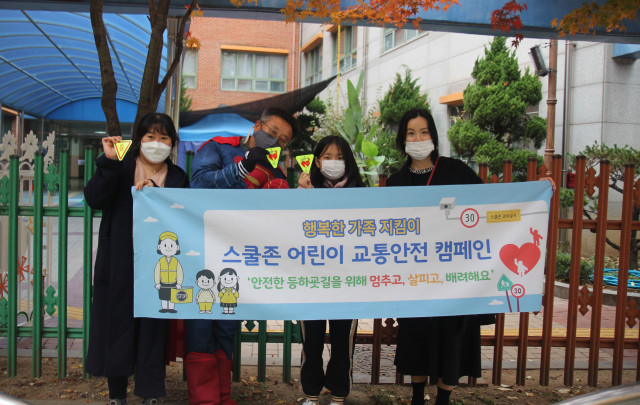 캠페인에 참여하는 슈퍼맨 서울보라매초등학교 김갑철 교장(왼쪽부터 두 번째)과 학생, 학부모가 기념사진을 찍고 있다