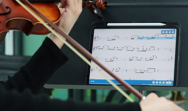 연주자가 수잔스 바이올린 앱으로 바이올린을 켜고 있다