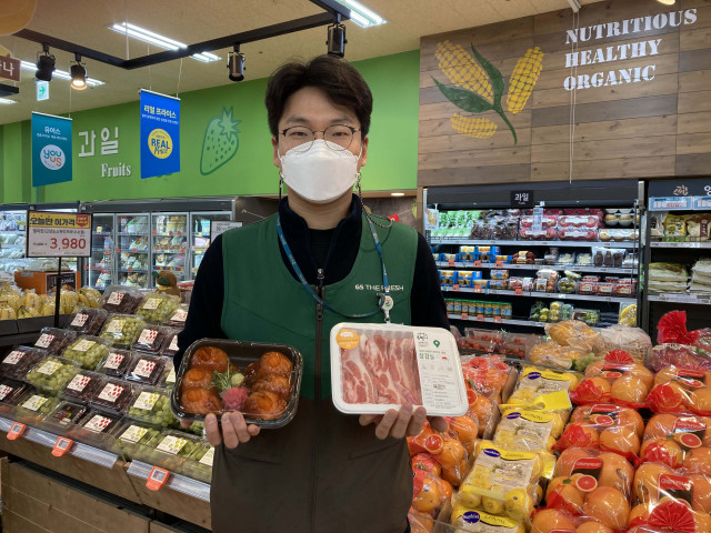 GS수퍼마켓에서 직원이 배달 인기 상품 삼겹살과 대왕연어초밥을 들고 있다