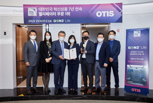조익서 오티스 코리아 사장(왼쪽 세 번째)이 황은주 한국경영인증원장(왼쪽 네 번째)으로부터 ‘2021 이노스타 인증: 대한민국 혁신상품 엘리베이터 부문 1위’ 인증서 및 상패를 받고 기념촬영을 하고 있다