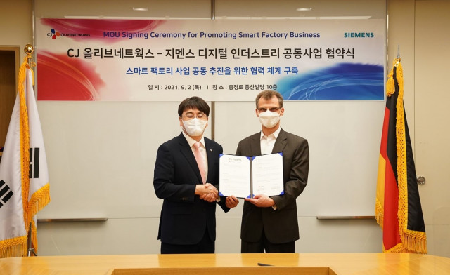 Thomas Schmid, Head of Digital Industries at Siemens Korea (Right), and InHyok Cha, CEO of CJ OliveNetworks (Left), pose for a photo after signing an MOU to jointly develop Smart Factory Business at Siemens Korea headquarters in Chungjeong-ro, Seodaemun-gu, Seoul, on September 2, 2021
