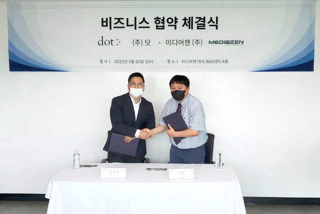 왼쪽부터 닷 김주윤 대표와 미디어젠 고훈 대표가 비즈니스 협약서 서명을 마친 뒤 악수를 나누고 있다