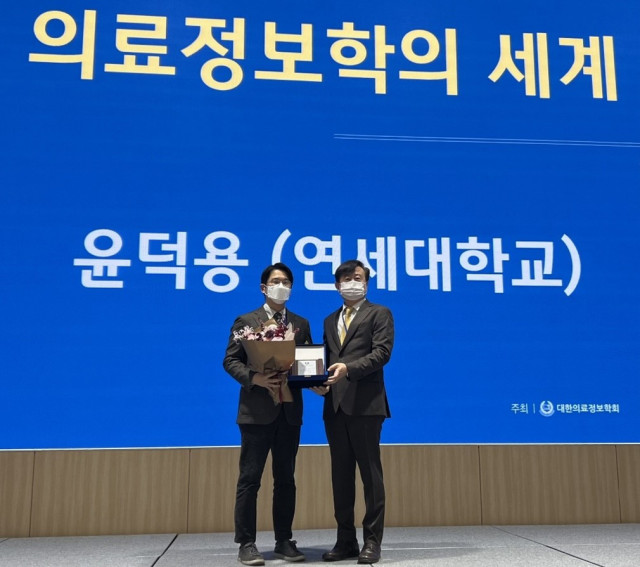 버드온 대표 윤덕용 연세대 교수(왼쪽)가 전북대학교 국제컨벤션센터에서 열린 2022 대한의료정보학회 추계학술대회에서 정보의학학술상을 수상하고 있다