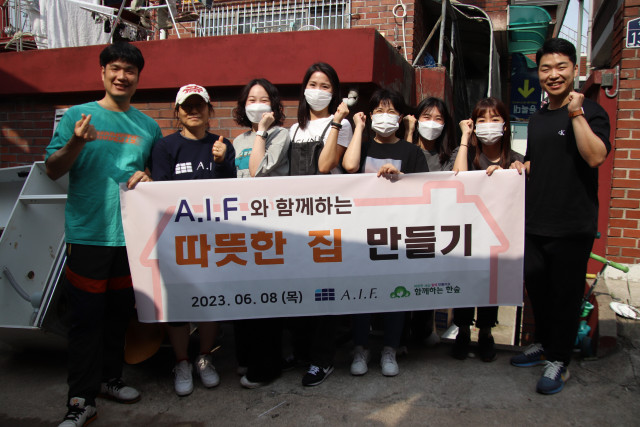 A.I.F 임직원이 봉사활동 후 단체 기념 촬영을 하고 있다