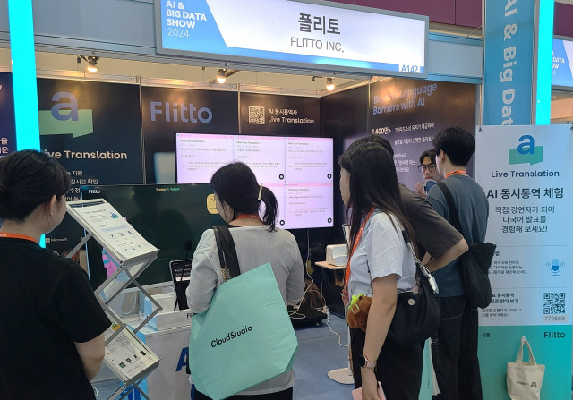 서울 강남구 코엑스에서 열리는 스마트테크 코리아 2024의 플리토 부스에서 참관객이 AI 대화형 통번역 솔루션을 체험하고 있다.