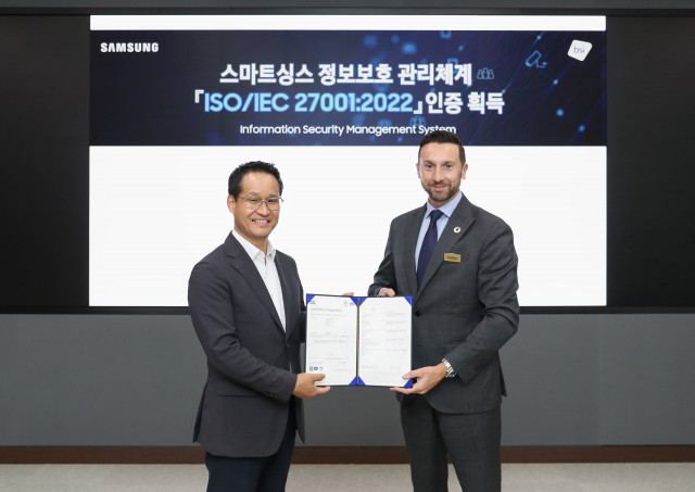 삼성전자 스마트싱스(SmartThings)가 ‘정보보호 관리체계’에 대한 국제표준 ISO/IEC 27001:2022 인증을 영국왕립표준협회(BSI)로부터 받았다. 왼쪽부터 삼성전자 디지털플랫폼센터장 최승범 부사장과 영국왕립표준협회 해롤드 프라달(Harold Pradal) 인증 서비스 부문장이 삼성전자 디지털시티에서 기념 촬영을 하고 있다