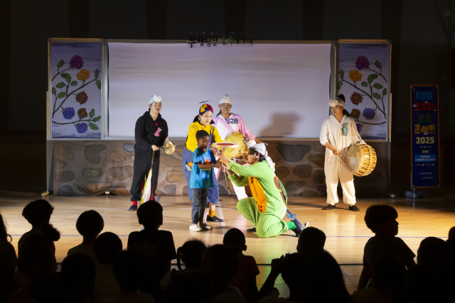 6월 18일 경기 동두천 보산초등학교에서 열린 ‘IBK 모두다 스쿨콘서트 2025’ 현장. 한 학생이 연주자들과 버나돌리기 체험을 하고 있다