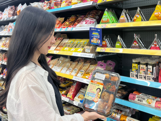 GS25에서 모델이 ‘혜자롭게 돌아온 명불허전’ 도시락을 선보이고 있다