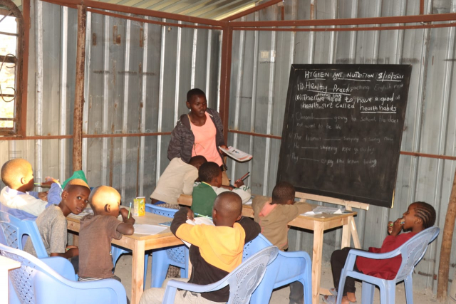 케냐 키베라 아이들이 방과 후 학교 교실에서 선생님의 수업을 듣고 있다(사진 : 월드쉐어 제공)