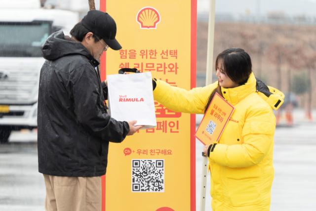 ‘리무라 졸음운전 방지 캠페인’ 행사 관계자가 대형 트럭 운전자에게 안전 패키지를 전달하고 있다