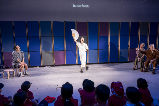 바이링구얼 판소리 긴긴밤 공연 중 소리꾼 이승희가 부채를 들고 있고, 배우 조 터너(Jo Turner)가 그를 가리키며 소개하고 있다(2026. 2. 13. 시드니오페라하우스 창의센터, 사진 시드니오페라하우스 제공 ⓒCassandra Hannagan)