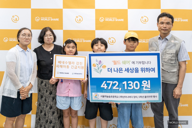 서울하늘숲초등학교 학생들이 월드쉐어 본부에서 바자회 수익금을 베네수엘라 지진 피해 성금으로 전달하고 있다