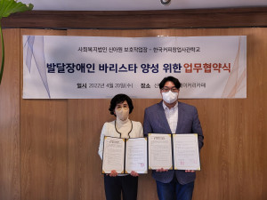 왼쪽부터 신아보호작업장 황성경 시설장과 한국커피창업사관학교 최용국 대표가 업무협약식에서 기념 촬영을 하고 있다