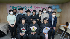 고등학교 검정고시를 합격한 강동야학 졸업생들이 교사들과 기념사진을 촬영하고 있다
