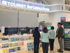 서울관광플라자에서 외국인 관광객들이 AI 기반 실시간 대화형 통번역 서비스인 ‘챗 트랜스레이션을 사용하며 서울시 캐릭터 해치로부터 여행 정보를 안내받고 있다.