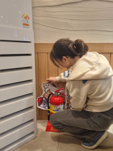 ‘소방냥이를 찾아라’ 캠페인에 참여한 유가네 닭갈비 방이점 직원이 소화기가 위치한 곳에 소방냥이 스티커를 부착하고 있다
