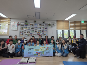 37.5 Movement Institute 결혼이민자 교육생들과 아산 LH15단지 경로당 어르신들이 함께 기념촬영을 하고 있다
