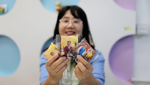 서울장애인종합복지관이 AI 기술로 발달장애인에게 특별한 한복 사진을 선물했다. 사진을 부착한 약과 선물을 받은 복지관 직원이 활짝 웃고 있다