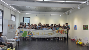 ‘모두의 창작’ 프로젝트 참가 아동들과 가족들, 영은하다 작가가 전시회 현수막 앞에서 기념 촬영을 하고 있다.