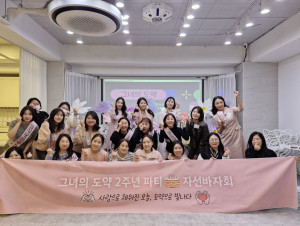 그녀의도약 2주년 행사에 참여한 멤버들이 현수막을 들고 기념 촬영한 모습. 참석자들이 함께 성장의 의미를 나누며 자선바자회를 마친 뒤, 감사와 축하의 순간을 기록했다