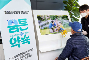 서초구 내 방배노인종합복지관에서 한 어르신이 ‘숨튼약속’ AI 인터랙티브 숨 건강 체험 장치를 통해 자신의 숨으로 ‘생명의 정원’을 완성하는 체험을 하고 있다