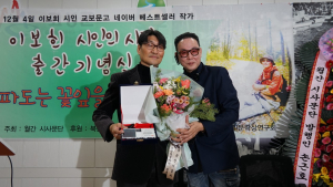월간 시사문단 손근호 발행인에게 출간패를 수여받는 이보희 시인
