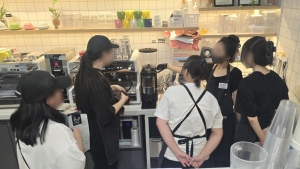 학교밖청소년들이 카페 일 경험에 앞서 진행된 기술교육에서 바리스타 강사로부터 에스프레소 머신 사용법을 배우고 있다