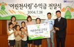 SK텔레콤 경영전략실장 지동섭 상무가 '어린 천사링' 수익금으로 만련한 피아노를 보육원 관계자들에게 전달하고 있다.