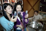 “휴대폰으로 노래 부르고 가수 되세요”, KTF 고객이 휴대폰으로 노래를 부르며 <매직엔 스타 오디션>에 참가하고 있다.