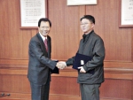 한정기 한국증권전산 사장(왼쪽)과 정용구 노조위원장이 임금 동결안에 합의한 후 서로 악수를 나누고 있다