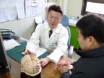 나형균 교수가 뇌경색 줄기세포이식을 받은 환자(탁씨, 39세, 남자)의 수술부위를 설명하며 진료를 보고있다.