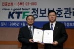 KTF 정보시스템 부문장 김기철 전무(좌측)가 이홍섭 한국정보보호진흥원장(우측)으로부터 정보보호관리체계 인증서를 받고 있다.