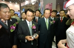 진대제 정보통신부 장관(사진 중앙)이 LG전자 전시관을 찾아 위성DMB폰(LG-SB120)을 손에 들고 유심히 보고 있다. 진대제 장관 오른쪽은 김재철 무역협회장.