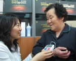 웰루킹 효도 행사를 통해 무료로 증정하는 혈압계로 소비자에게 혈압을 측정해주고 있는 모습 