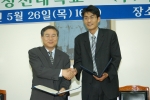 5월 26일 한일장신대 임희모 기획처장(왼쪽)과 (주)바이지온 윤정호 대표가 협약서 체결 및 교환한 후 악수하고 있다.