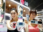 LG전자 전시부스 앞에서 싱가폴 현지 도우미들이 LG전자의 3G폰, 3D게임폰, 500만 화소 디카폰, 위성DMB폰(왼쪽부터)을 들고 포즈를 취하고 있다.