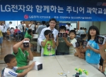 지난 25일 서울 마천복지관에서 열린 ‘주니어 과학교실’에서 아이들이 일일 과학교사로 나선 LG전자 연구 원들과 함께 광섬유와 아크릴 막대를 이용해 빛나는 액자를 완성해서 들어 보