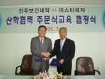 미스터피자의 황문구 대표와 진주보건대학 정종권 학장이 협정을 맺고 악수를 나누고 있다.

