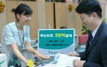 하나은행창구에서 직원이 활짝 웃으며 후순위채에 대해 고객에게 설명하고 있는 모습임