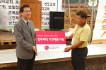 LG전자 박낙원 사회공헌그룹장이 14일 춘천에서 열린‘사랑의 집’입주식에서 입주민 대표에게 가전제품을 기증하고 있다.