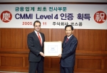한정기 코스콤 사장(오른쪽)이 호세 아리아스 카네기멜론대학 소프트웨어공학연구소 선임심사관으로부터 CMMI 레벨4 인증을 획득하고 기념사진 포즈를 취하고 있다