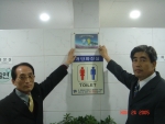 우수화장실로 인증된 화장실 입구에 인증패를 붙이고 있는 모습