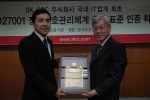 정재현 SK C&C 전무(왼쪽)가 천정기 BSI Korea사장으로부터 ISO27001 인증서를 전달받고 기념촬영을 하는 모습.