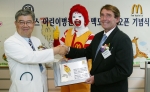 29일 한국 맥도날드의 지원으로 건립된 세브란스 어린이병원 학교 오픈을 기념해 김덕희 세브란스 어린이병원장이 한국맥도날드 레이 프롤리 사장에게 현판을 전달받고 있다.