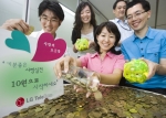 LGT 직원들이 자신의 돼지저금통과 책상서랍에서 보관 중인 10원짜리 동전을 모금함에 내놓고 있는 장면