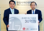 김쌍수 LG전자 부회장(사진 왼쪽)이 최학래 전국재해구호협회 회장에게 수재민 돕기 성금을 전달하고 있는 모습 .