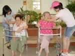 삼성SDS 임직원 자녀들이 사탕을 엮어 손수 만든 목걸이를 신내노인요양원 할머니들에게 걸어드리고 있다.