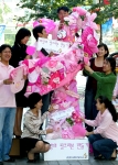 한국아스트라제네카 직원들이 기부한 핑크 소지품을 붙여 핑크리본을 만들고 있다.